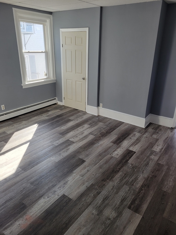 194 Buffinton Street, Unit 1 Fall River, MA 02721 - Photo 4 of 6 an empty room with wooden floor and windows