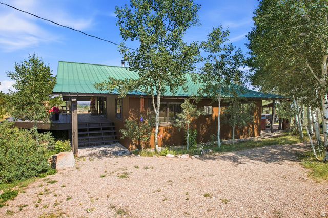 1663 Lancer Lane Evanston, UT 82930 - Photo 57 of 101 Wood-sided residence with a green metal roof and a spacious elevated deck