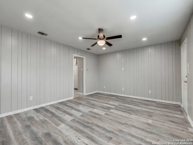 a view of an empty room and a ceiling fan