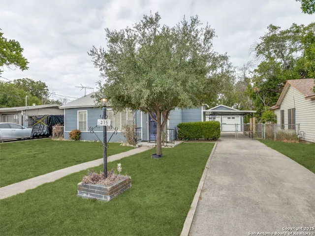 a front view of a house with a yard garden and trees