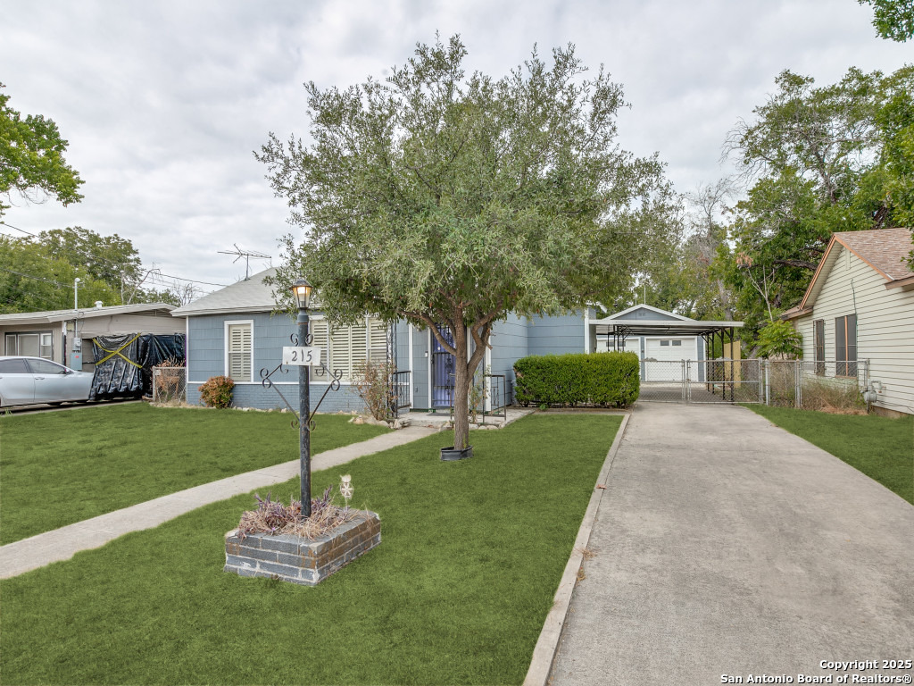 215 Midland Drive San Antonio, TX 78219 - Photo 13 of 35 a front view of a house with a yard garden and trees
