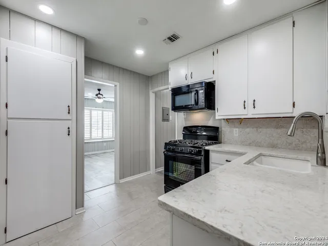 a kitchen with granite countertop a refrigerator stove and sink