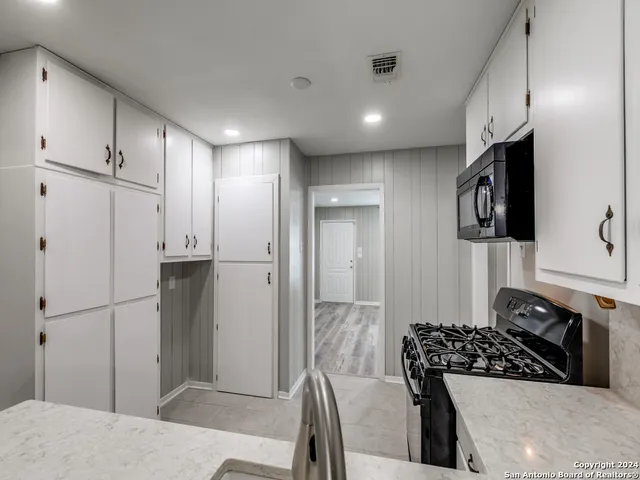 a kitchen with stainless steel appliances granite countertop a refrigerator and a stove top oven