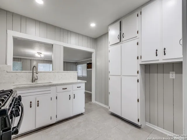 a kitchen with white cabinets and refrigerator