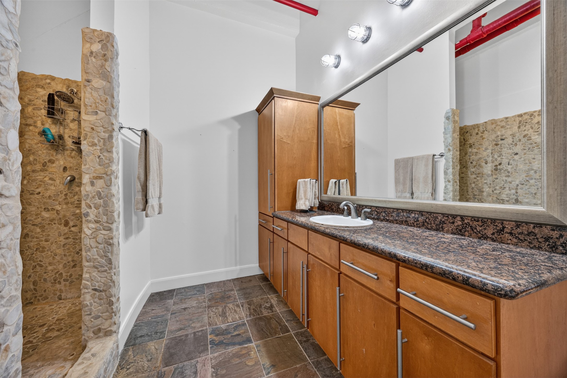 705 Main Street, Unit 513 Houston, TX 77002 - Photo 6 of 22 a bathroom with a granite countertop sink a mirror and shower