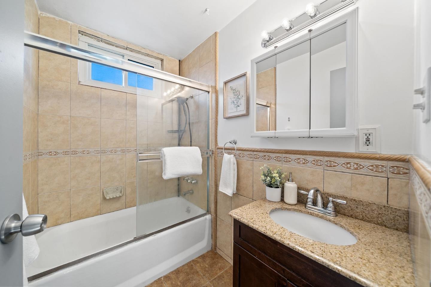 654 Foothill Drive Pacifica, CA 94044 - Photo 19 of 24 a bathroom with a granite countertop bathtub shower sink vanity and mirror
