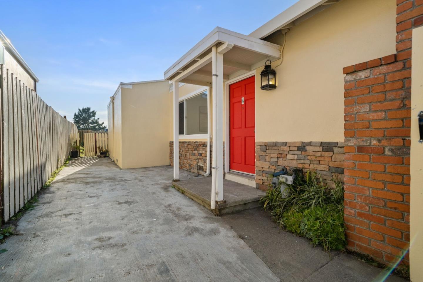 654 Foothill Drive Pacifica, CA 94044 - Photo 4 of 24 a yellow house with a small yard and wooden fence