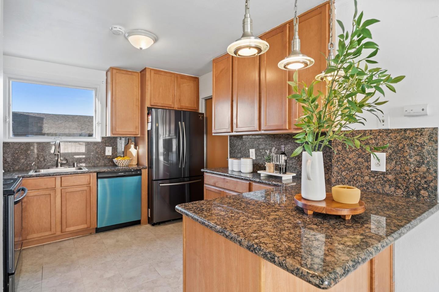 654 Foothill Drive Pacifica, CA 94044 - Photo 9 of 24 a kitchen with stainless steel appliances granite countertop a sink a stove and a wooden floors