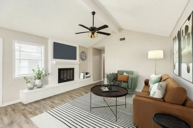 a living room with furniture a fireplace and a flat screen tv