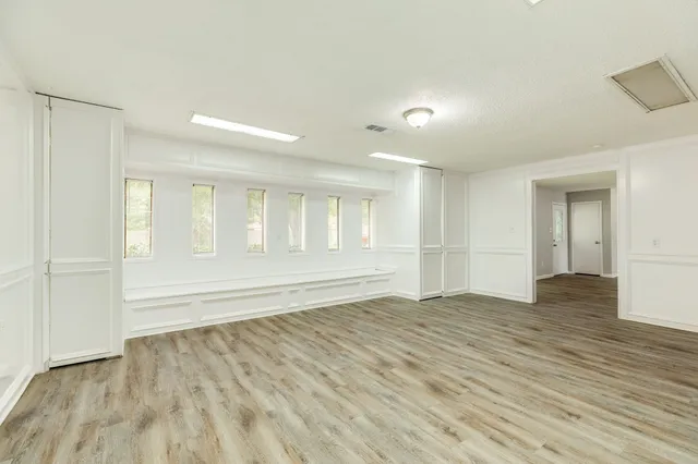 a view of an empty room with wooden floor