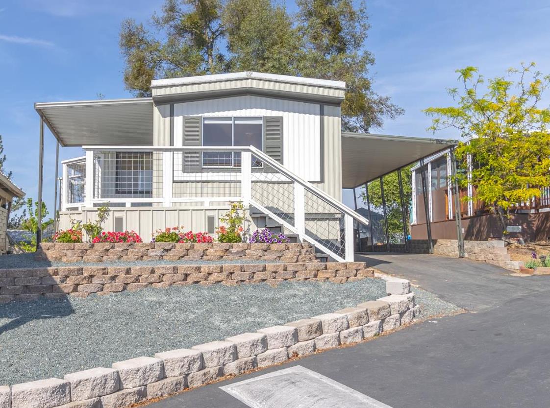 a front view of a house with a yard and potted plants