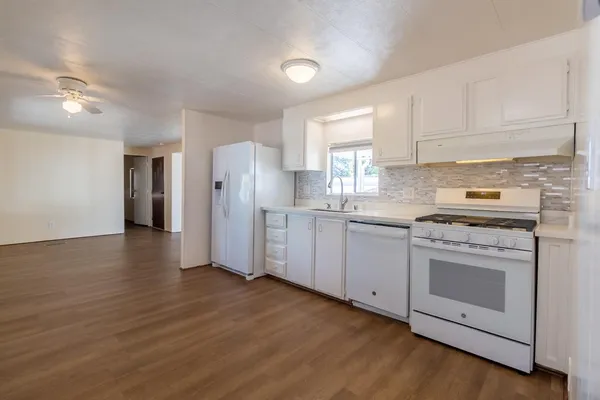 a kitchen with stainless steel appliances white cabinets and a refrigerator