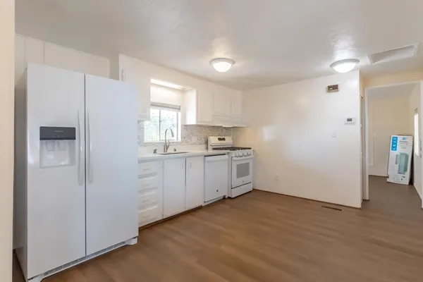 a kitchen with white cabinets and white appliances