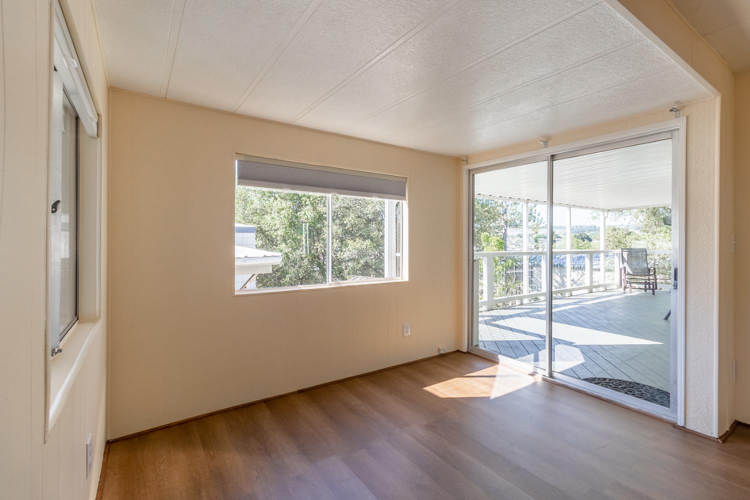 150 Clinton Road, Unit 5 Jackson, CA 95642 - Photo 9 of 22 a view of an empty room with wooden floor and a window