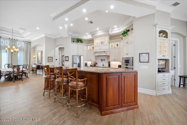a kitchen with stainless steel appliances kitchen island granite countertop furniture and a wooden floors