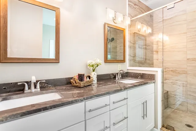 a bathroom with a granite countertop sink toilet and shower