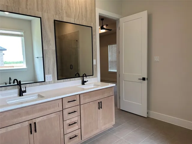 a bathroom with a double vanity sink and mirror