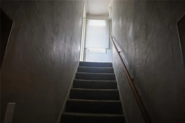 a view of staircase with white walls and a window
