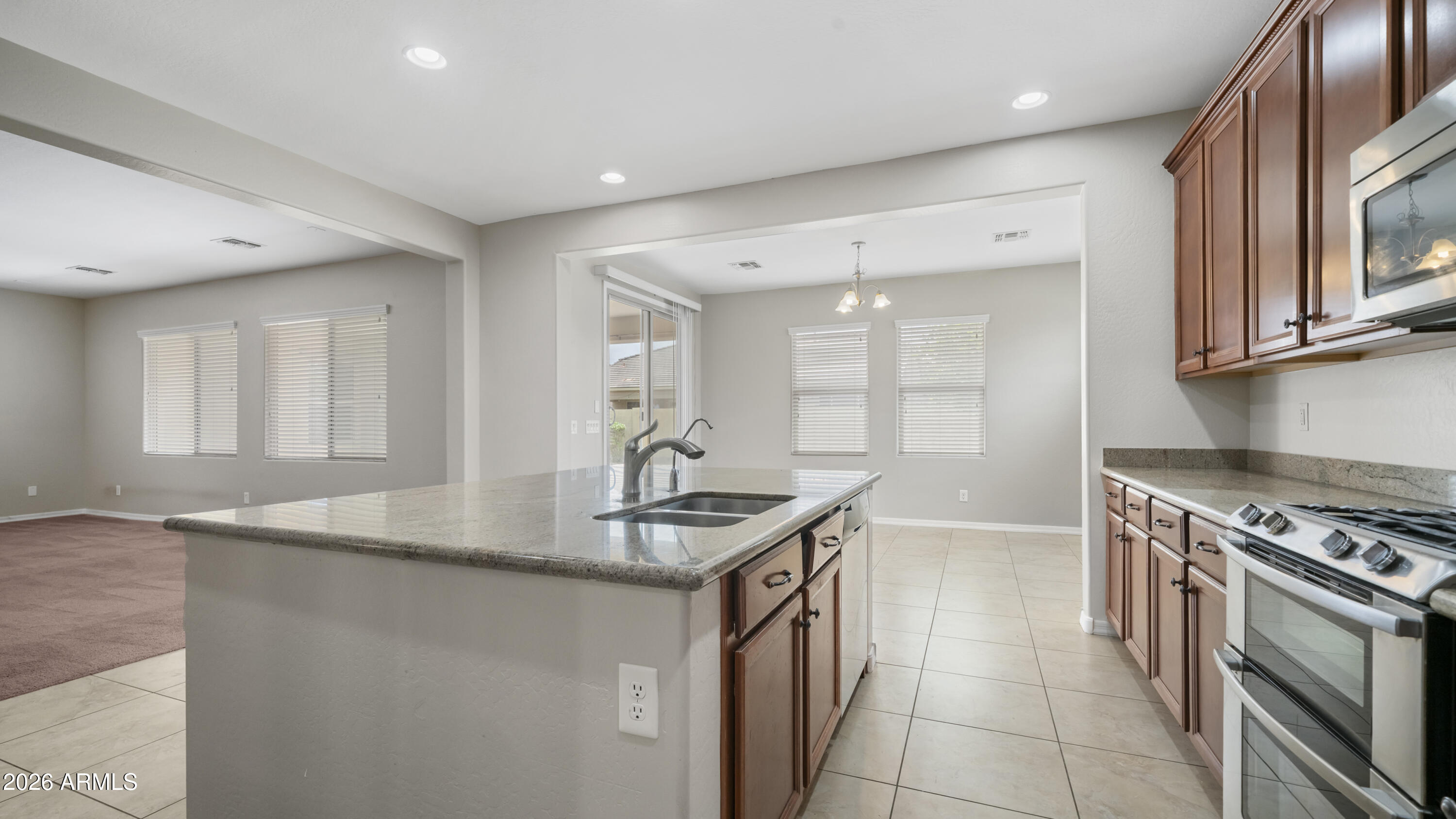 16159 West Granada Road Goodyear, AZ 85395 - Photo 17 of 41 a kitchen with stainless steel appliances granite countertop a sink stove and cabinets