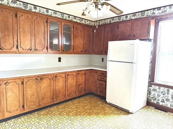 a kitchen with a refrigerator a stove top oven and cabinets