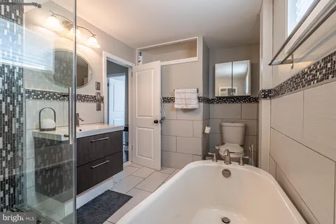a bathroom with a tub sink and mirror
