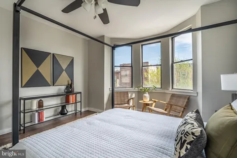 a bedroom with a bed a large window with the outer view