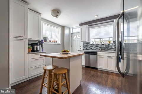 a kitchen with a refrigerator and white cabinets