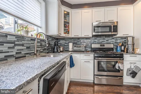 a kitchen with granite countertop a stove and a microwave