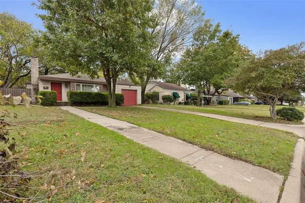 a front view of a house with a yard and trees