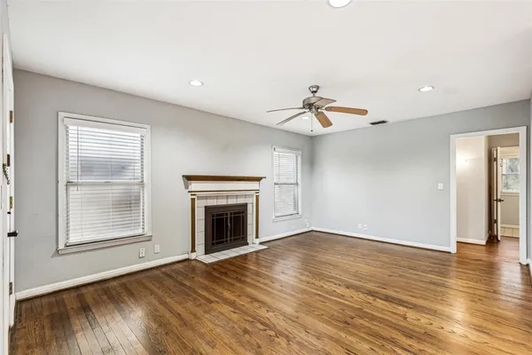a view of empty room with wooden floor fireplace and windows