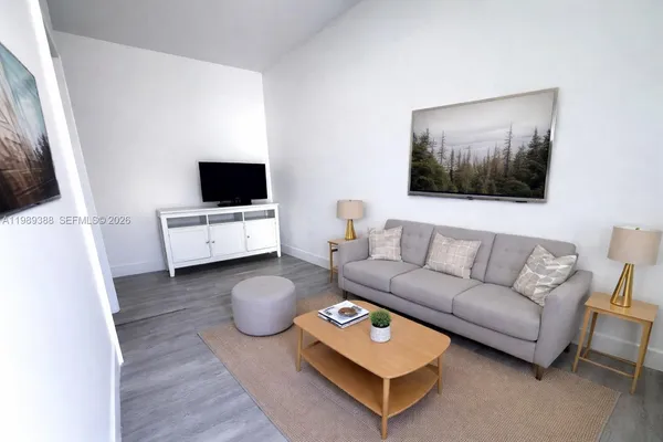 a living room with furniture a flat screen tv and a couch