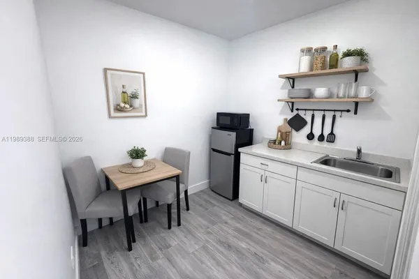 a kitchen with a table chairs and wooden floor