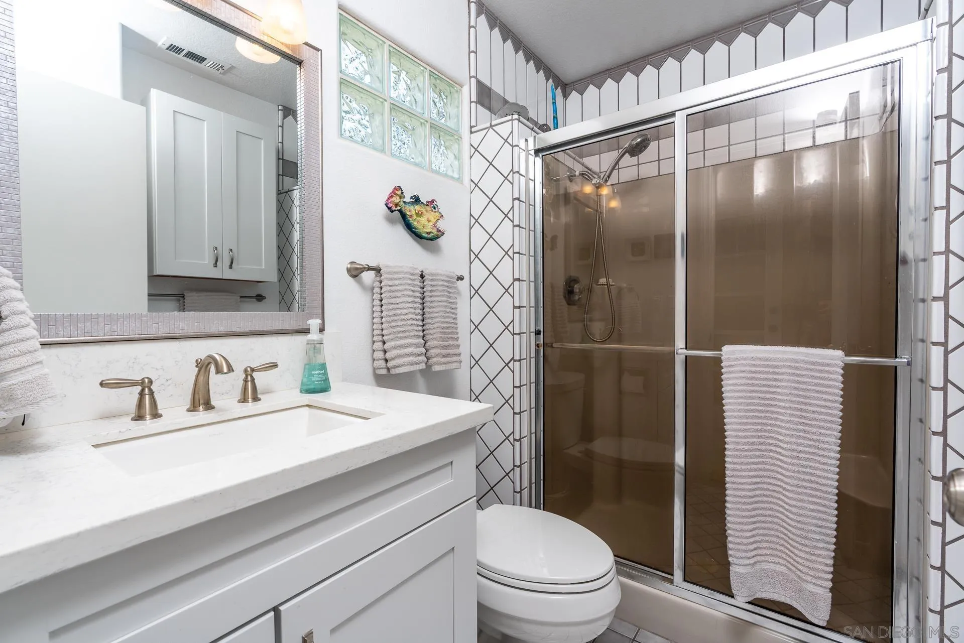 1269 Rainbow Ridge Lane Encinitas, CA 92024 - Photo 15 of 27 a bathroom with a sink a toilet and shower