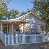 a view of house with a small yard and wooden fence