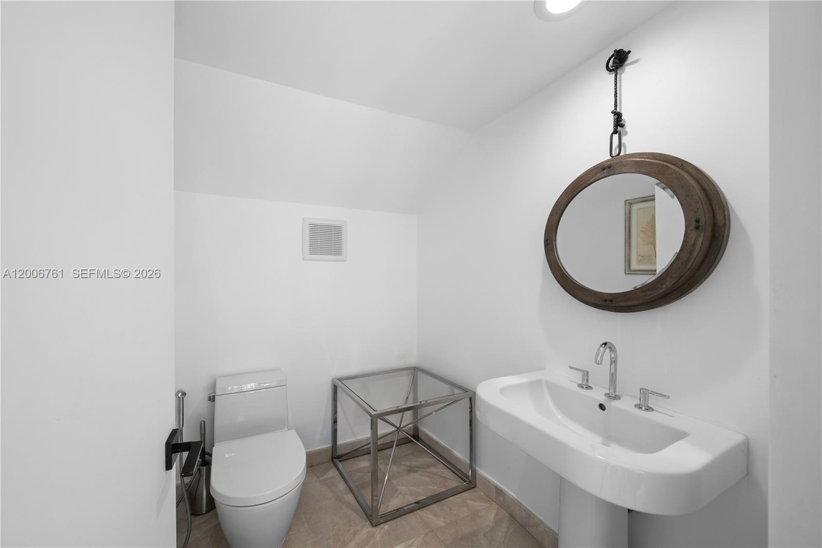 400 Alton Road, Unit TH1A Miami Beach, FL 33139 - Photo 14 of 32 a bathroom with a toilet a sink and a mirror