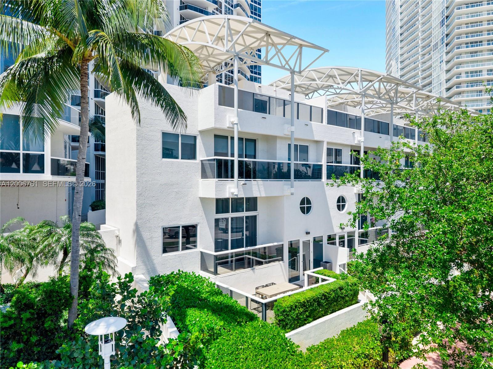 400 Alton Road, Unit TH1A Miami Beach, FL 33139 - Photo 2 of 32 a aerial view of a white building with a yard and potted plants