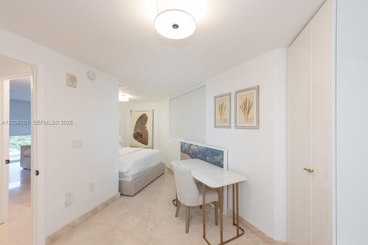 400 Alton Road, Unit TH1A Miami Beach, FL 33139 - Photo 22 of 32 a bedroom with a bed and a chair