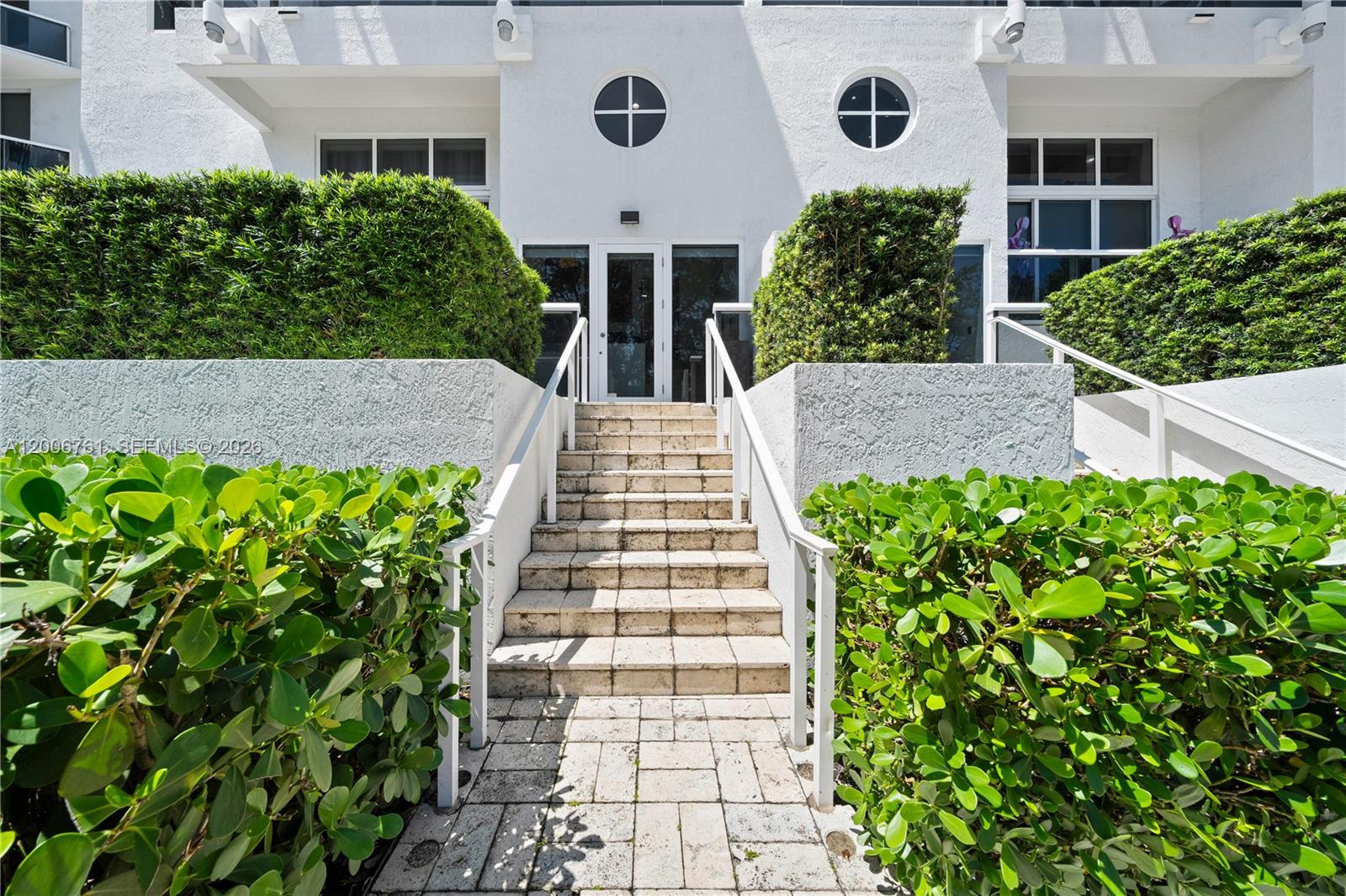 400 Alton Road, Unit TH1A Miami Beach, FL 33139 - Photo 4 of 32 a front view of a multi story residential apartment building with a yard