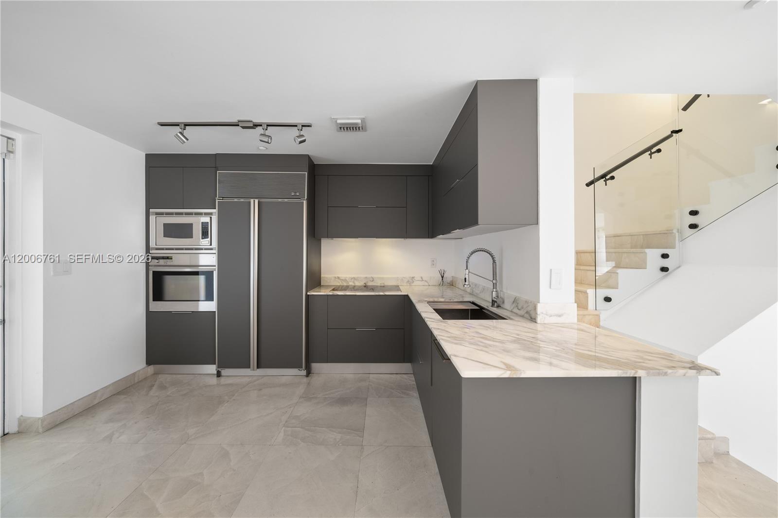 400 Alton Road, Unit TH1A Miami Beach, FL 33139 - Photo 6 of 32 a kitchen with stainless steel appliances granite countertop a sink and a refrigerator