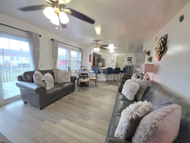 a living room with furniture a flat screen tv and kitchen view