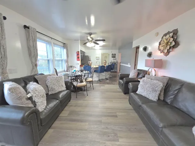 a living room with lots of furniture and a view of kitchen