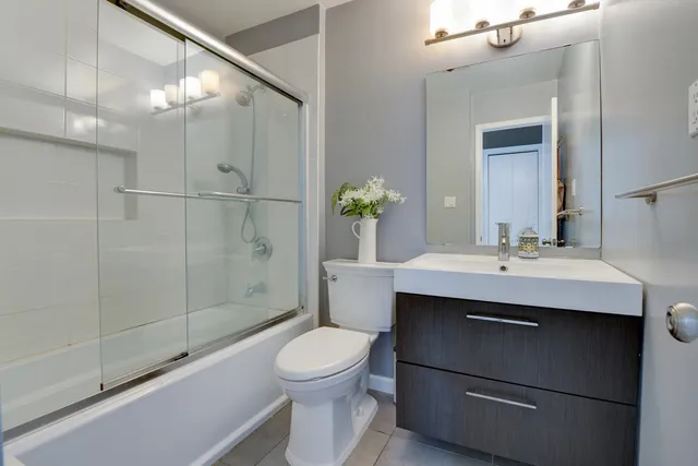 a bathroom with a sink toilet a mirror and shower