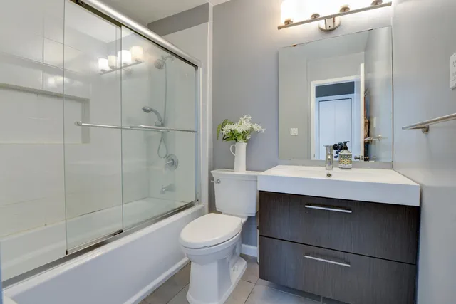 a bathroom with a sink toilet a mirror and shower