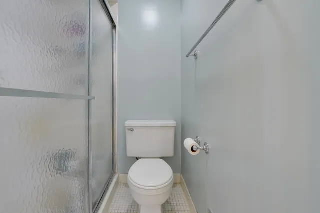 a white toilet sitting next to a shower