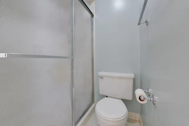 a white toilet sitting next to a shower