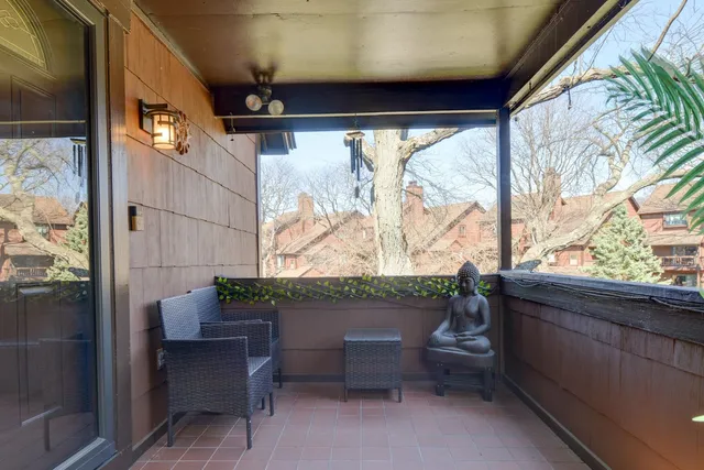 a view of a street with a bench and large trees