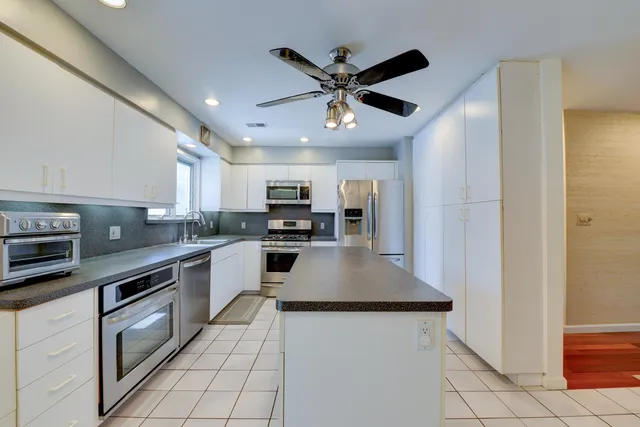 a kitchen with stainless steel appliances a refrigerator a stove top oven a sink and dishwasher