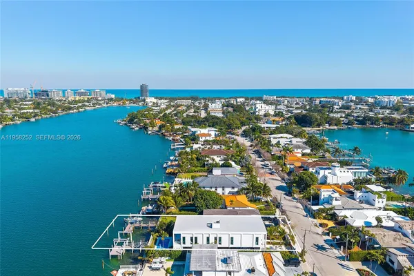 an aerial view of ocean and residential houses with outdoor space