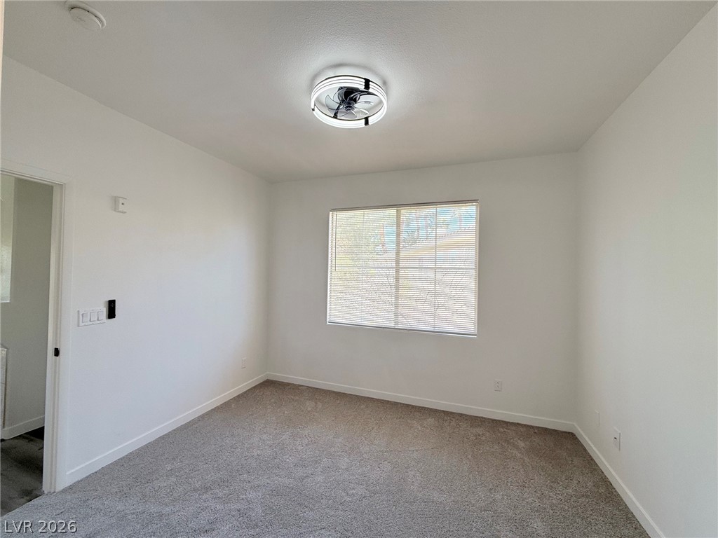 9050 West Warm Springs Road, Unit 2002 Las Vegas, NV 89148 - Photo 32 of 46 This versatile room features plush carpeting, a wide window, and modern lighting, ideal for personalization.