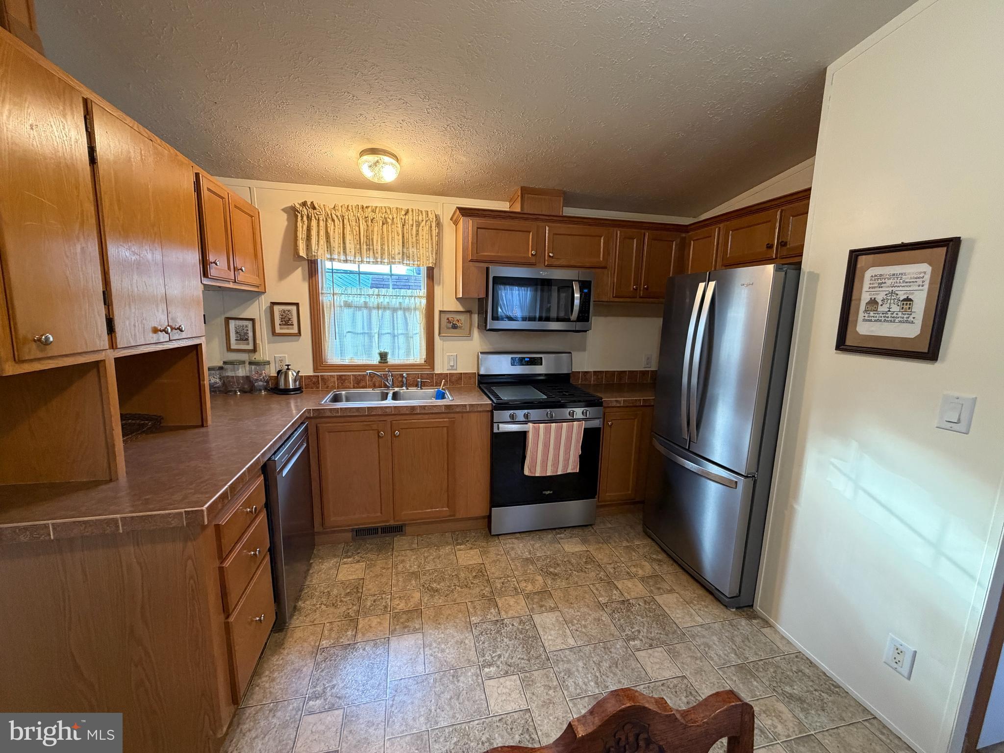 110 Dawn Street Quarryville, PA 17566 - Photo 14 of 29 a kitchen with stainless steel appliances granite countertop a refrigerator a stove a sink a microwave and island